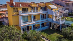 A multi-story building with balconies, a covered outdoor area, and a clear sky. - Apartment 616/1479 (Istria - Rovinj), 500m from the beach (Rovinj)