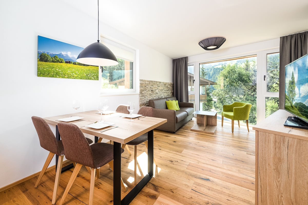 Una sala de estar moderna con comedor, un sofá y un televisor.