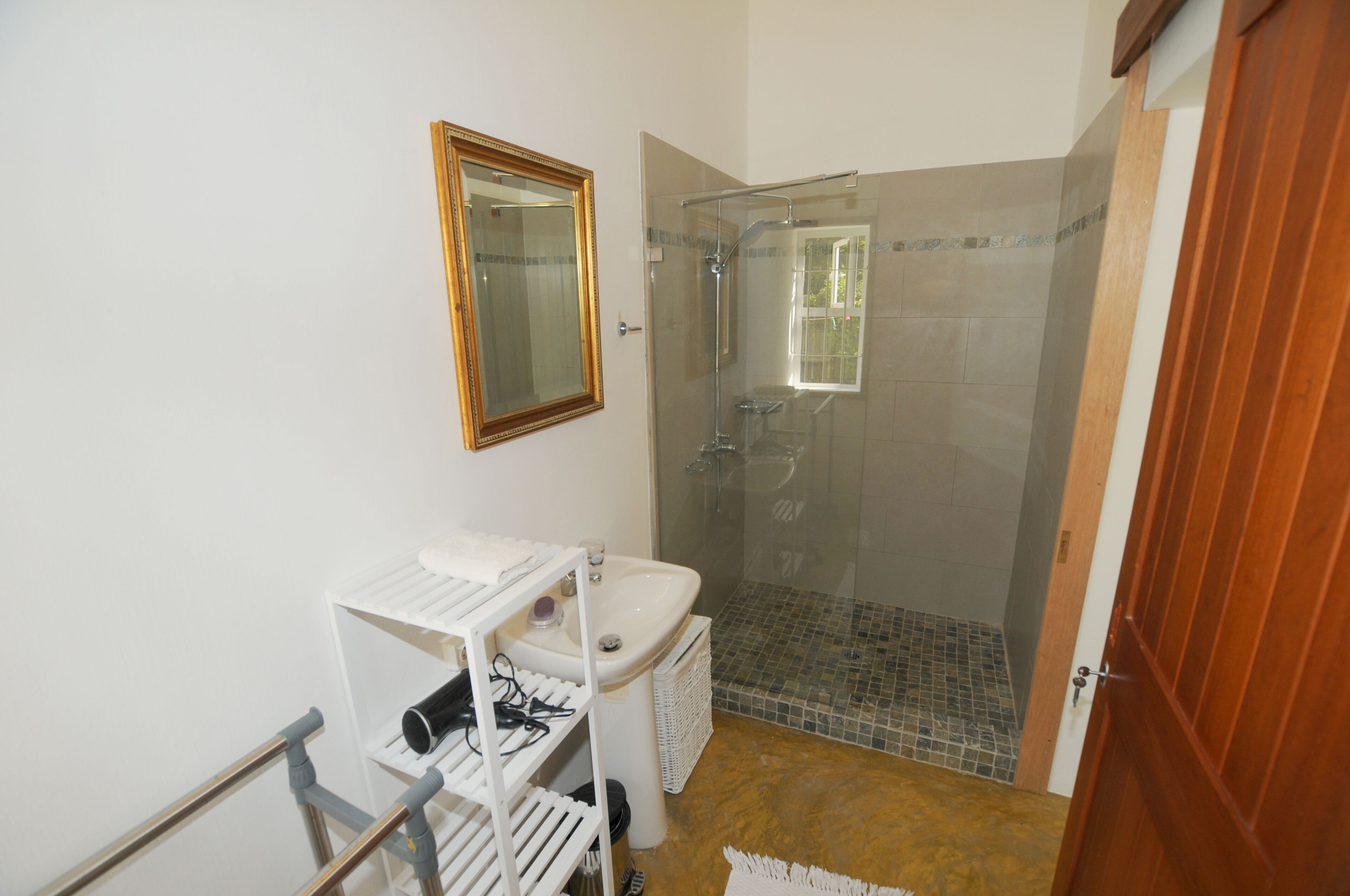 Un baño con ducha, lavabo y espejo.