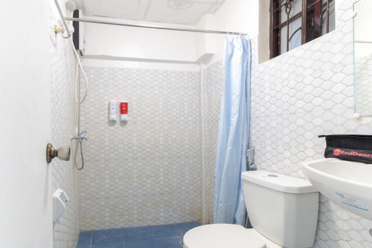 Un baño pequeño y funcional con ducha, inodoro y lavamanos.