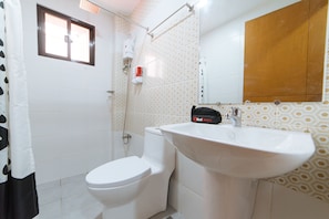 A bathroom with a toilet, a sink, and a shower. - RedDoorz Plus @ JNV Dream Hotel Subic Zambales (Subic)