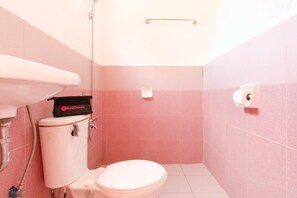 A small bathroom with a toilet, sink, and a shower.