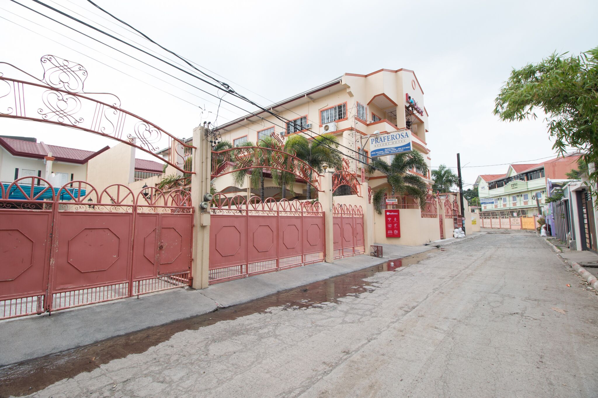 A multi-story building with a red gate and a sign that reads "Paferosso."