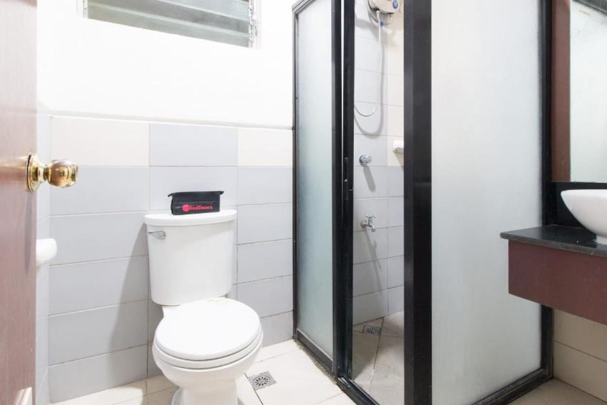 Une salle de bain comprenant des toilettes, un espace douche et un lavabo.