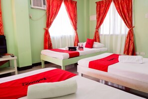 A hotel room with two beds, each with a red and white bedspread, and a television on a stand. - RedDoorz near Maribago Barangay Hall (Lapu-Lapu)
