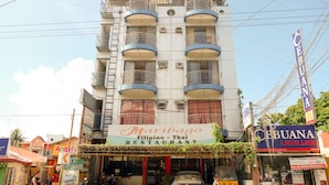 Um edifício de vários andares com um restaurante chamado 'Maribago Filipino - Thai' no andar térreo.