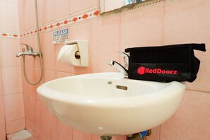 A bathroom sink with a towel rack and a sign instructing not to throw paper towels in the toilet. - RedDoorz near Maribago Barangay Hall (Lapu-Lapu)