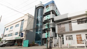 A multi-story building with a modern architectural design, featuring a mix of glass and concrete facades. - RedDoorz near Liceo De Cagayan University Highschool (Cagayan de Oro)