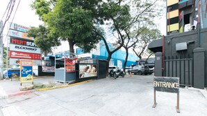 Une vue de rue avec une enseigne indiquant les commerces « Panay TULCO » et « Meatsun », un panneau « Stop » et une enseigne « Entrée ».