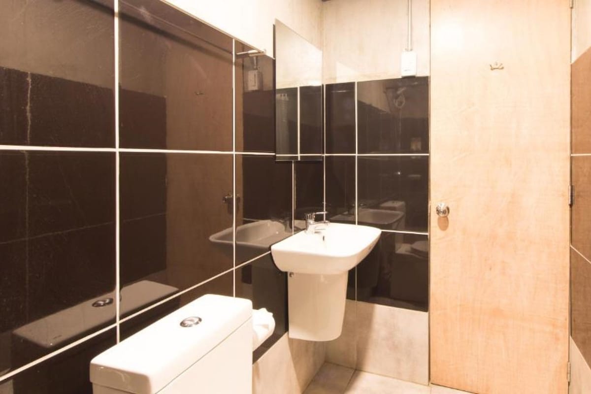 Ein modernes Badezimmer mit einem weißen Waschbecken, einer Toilette und einer Duschkabine.