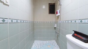 Un baño pequeño con inodoro, ducha y ventana.