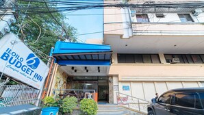 Un edificio con un letrero que dice 'Lolo Budget Inn' y un toldo azul.
