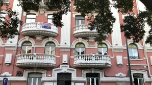 A pink building with balconies and a cafe sign. - Be Lisbon Residence Marquês (Lisbon)