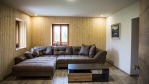 Una sala moderna con un sofá seccional, un pequeño reposapiés y una mesa de centro.