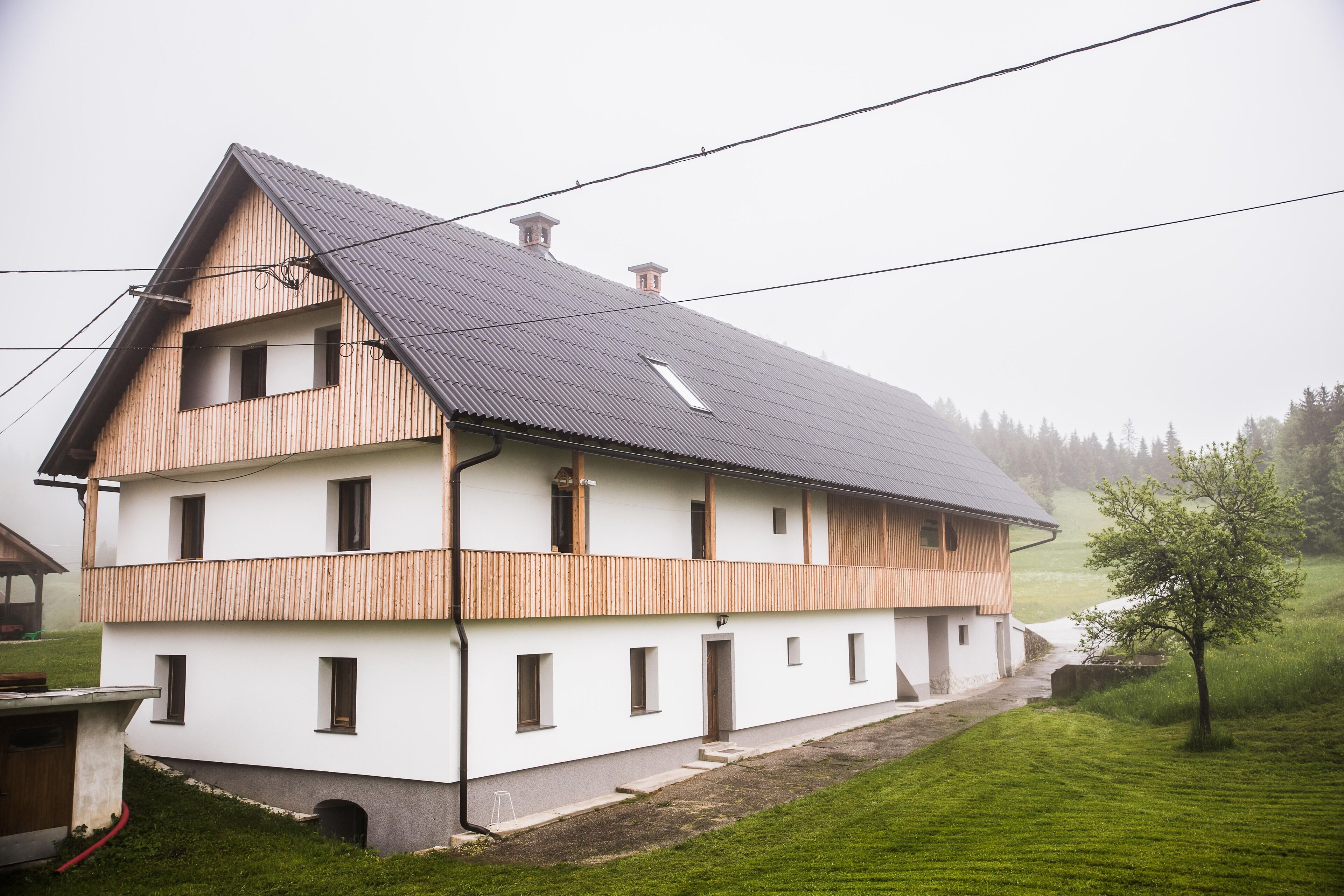 A two-story house with a sloped roof and wooden exterior.