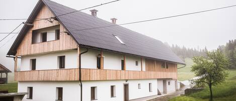 A two-story house with a sloped roof and wooden exterior.