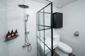 A modern bathroom with a glass shower enclosure, a white toilet, and a black medicine cabinet. - Soo Village (Seogwipo)