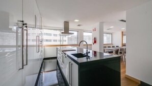 A modern kitchen with a central island, stainless steel appliances, and a large window providing natural light.