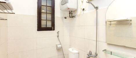 Un baño con inodoro, bidé, toallero y cabina de ducha de vidrio.