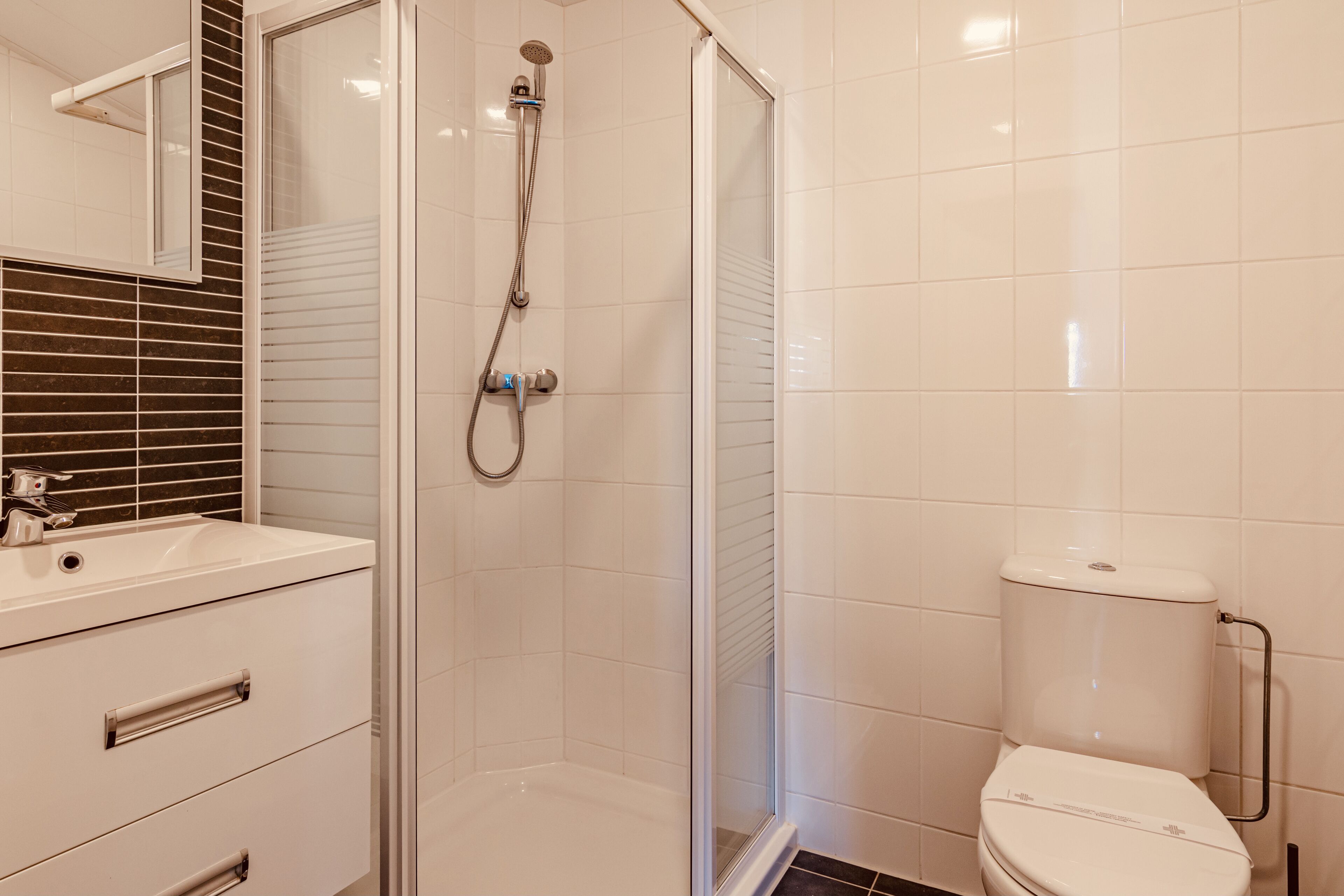 A bathroom with a shower, toilet, and sink.
