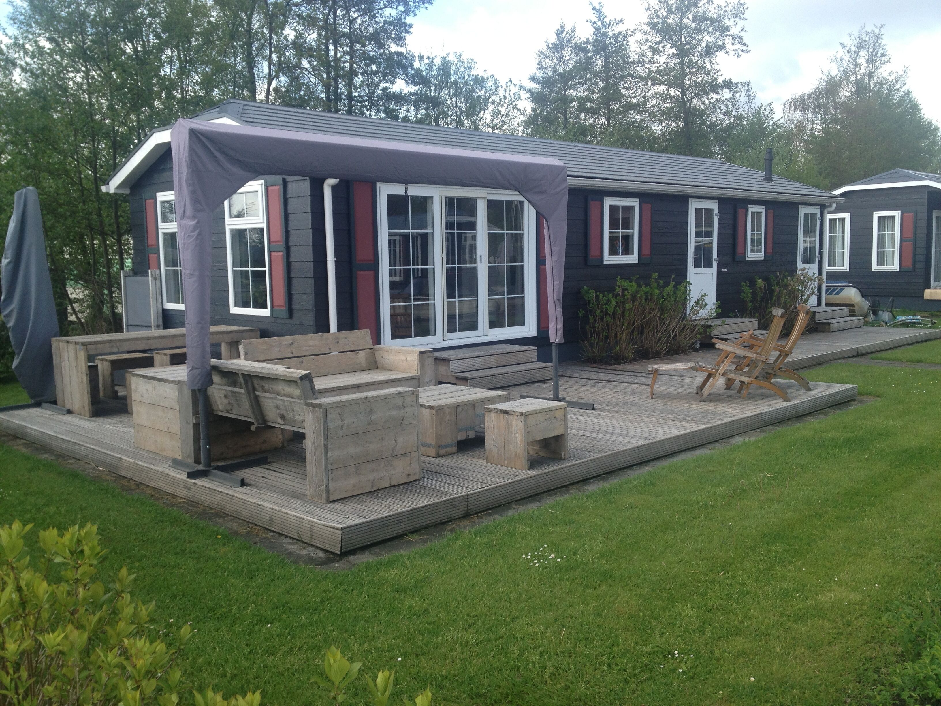 A house with a covered patio area, outdoor seating, and a small garden.