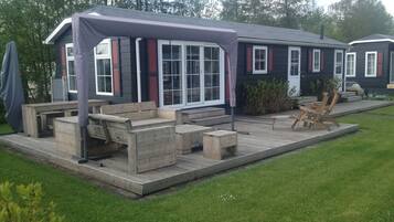 A house with a covered patio area, outdoor seating, and a small garden.