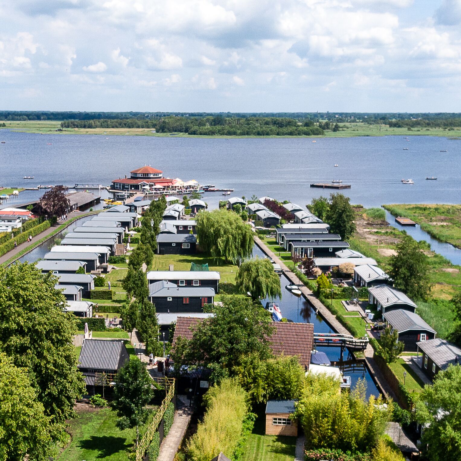A lakeside residential area with houses, a dock, and a boat.