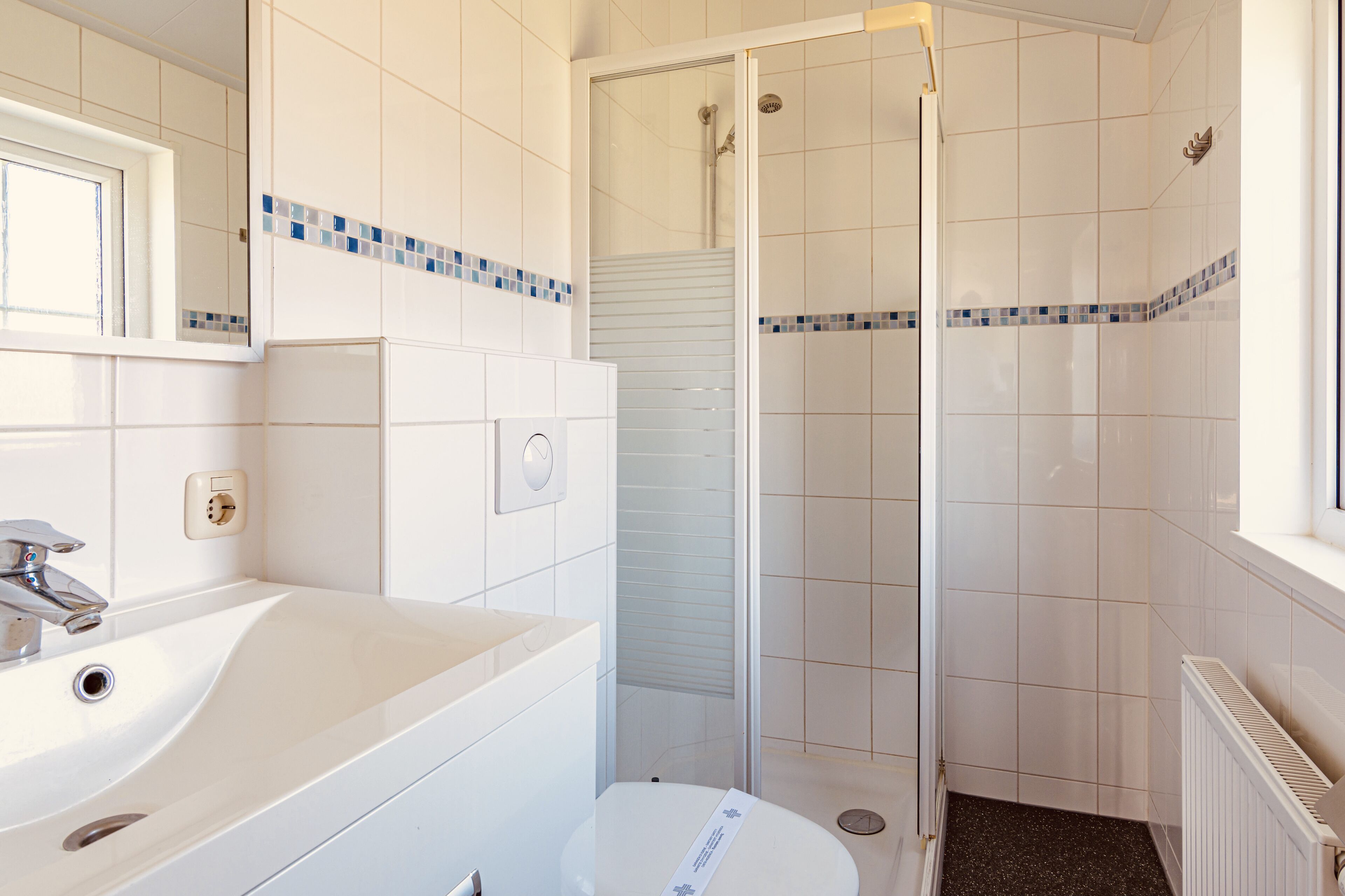 Ein Badezimmer mit Waschbecken, Toilette und Duschbereich.