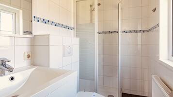 Ein Badezimmer mit Waschbecken, Toilette und Duschbereich.