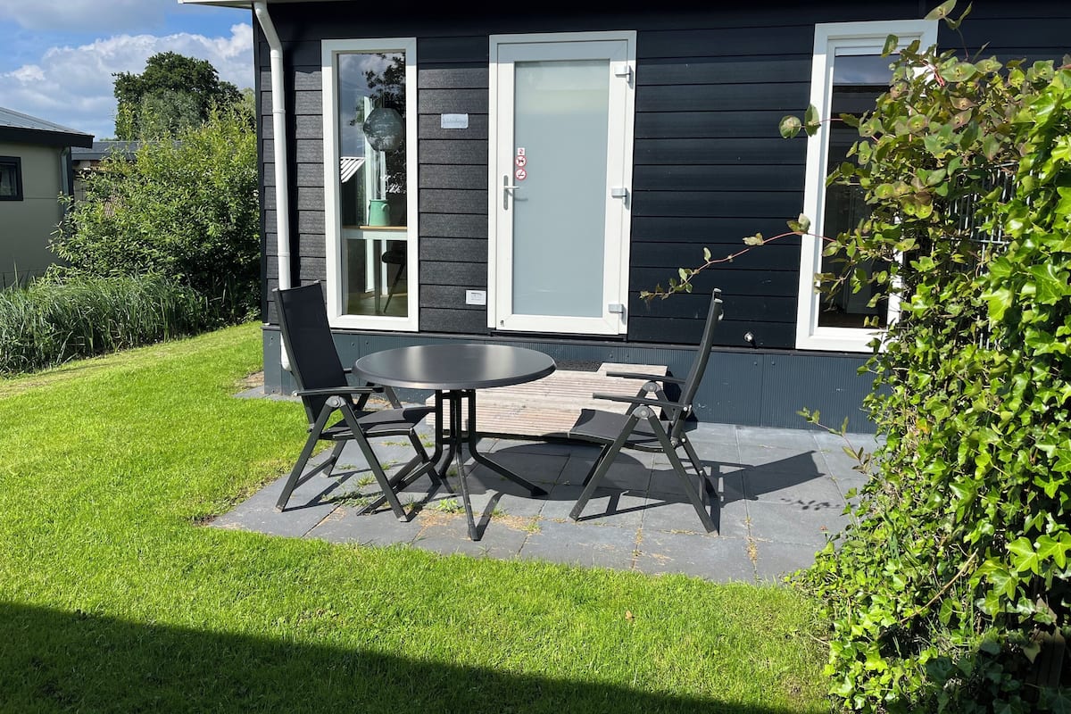 Una casa moderna con un patio, una mesa y dos sillas.