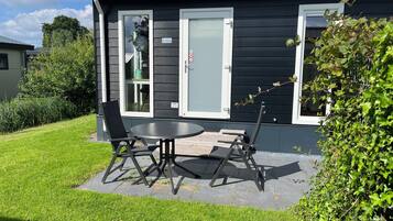 Ett modernt hus med en uteplats, ett bord och två stolar.