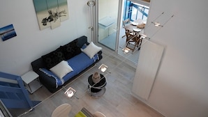 A modern living room with a sofa, a dining table with chairs, and a view through a glass door to an outdoor area. - Apartment with terrace, parking and port view in Capbreton (Capbreton)