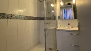 A bathroom with a shower, a sink, and a mirror. - Apartment with terrace, parking and port view in Capbreton (Capbreton)