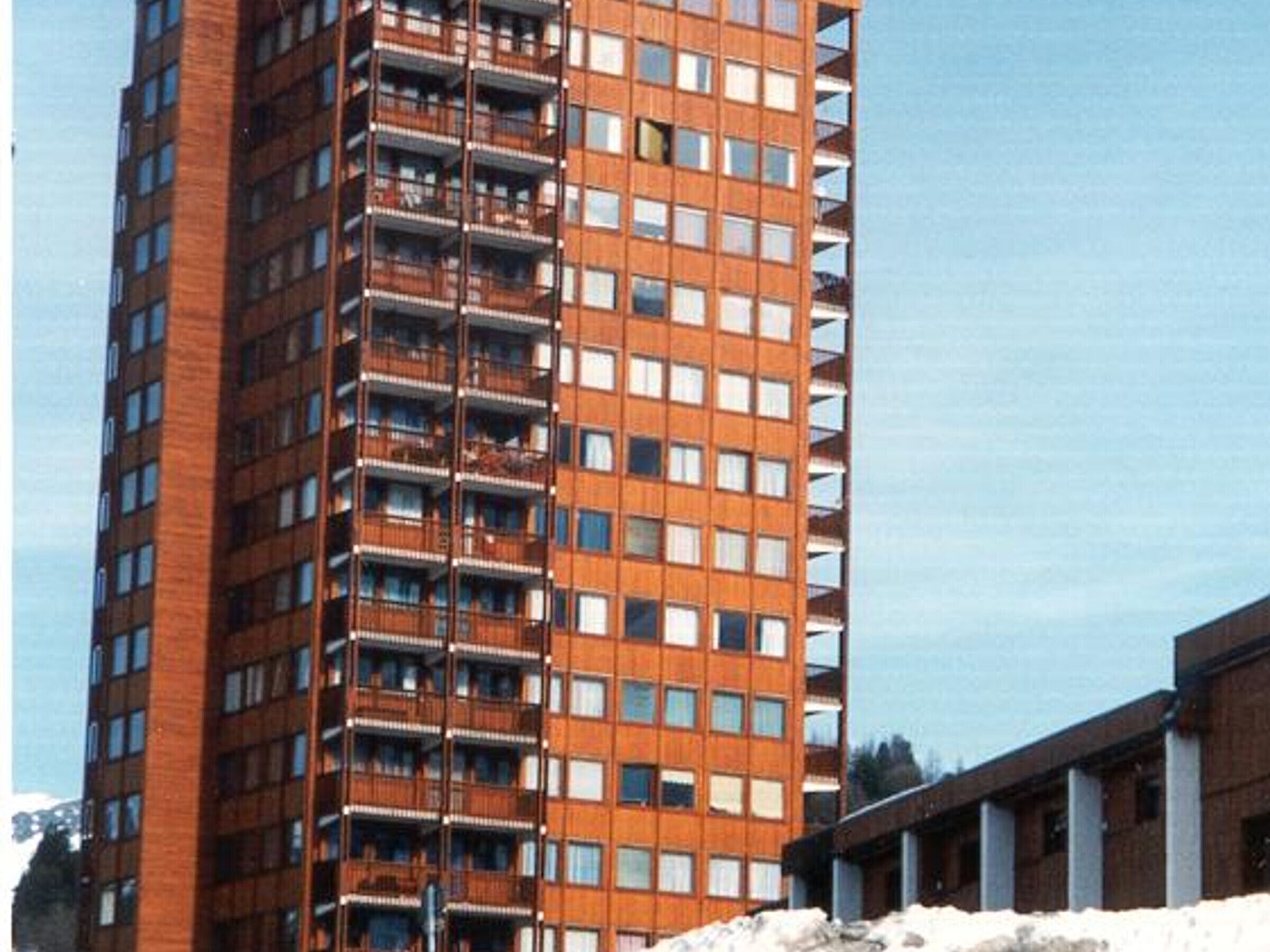 Um edifício alto com várias varandas e fachada de tijolos.
