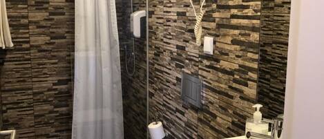 A modern bathroom with a shower, toilet, and sink.