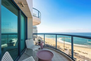 Ein Balkon mit Blick auf Strand und Meer.