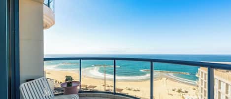 A balcony with a view of a beach and ocean.