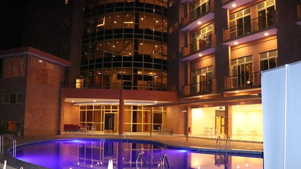 Un hotel con piscina, varias plantas y un diseño arquitectónico moderno.