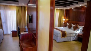 Una habitación de hotel con una cama, un escritorio y una silla.