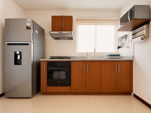 A modern kitchen with a built-in refrigerator, oven, and microwave.