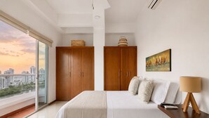 Un dormitorio con una cama grande, un armario de madera y vistas a la ciudad.