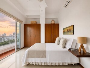Un dormitorio con una cama grande, un armario de madera y vistas a la ciudad.