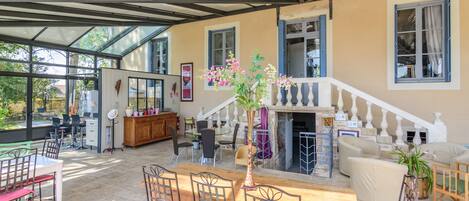 Un'ampia zona giorno con un tavolo da pranzo in legno, sedie e una scala che conduce a un piano superiore.