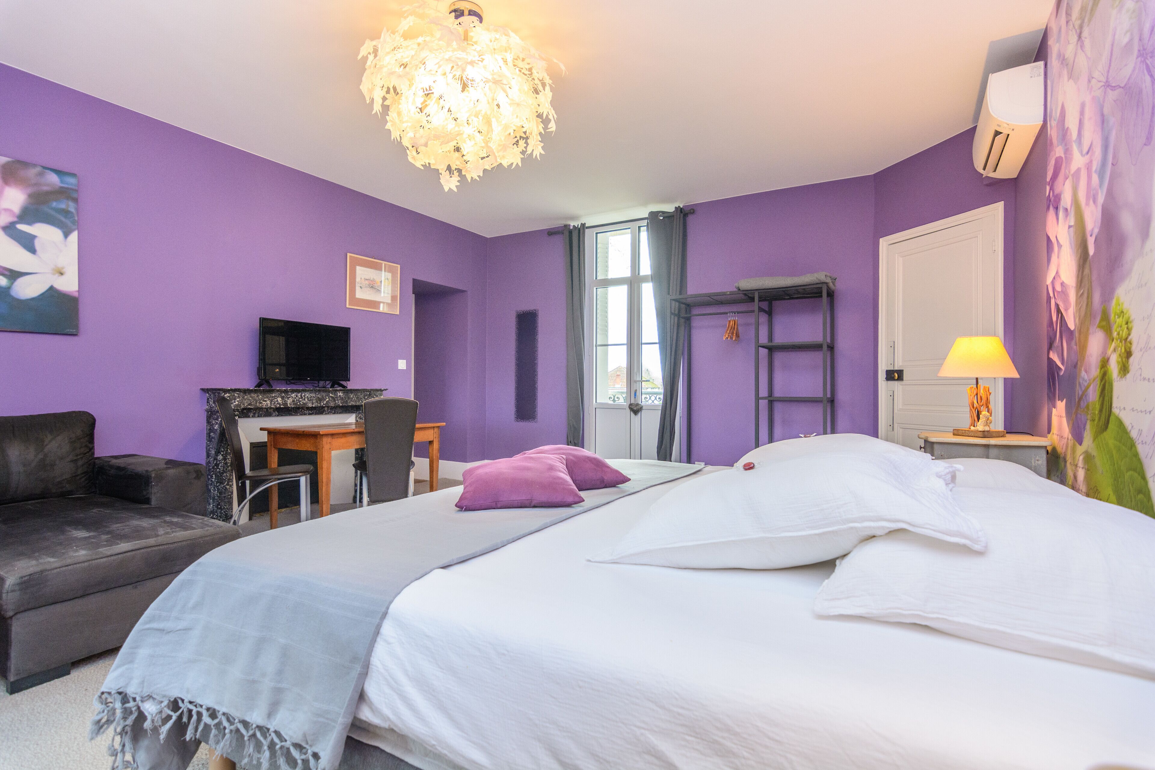 Ein Zimmer mit Bett, Schreibtisch, Stuhl, Sofa, Fernseher und Fenster.