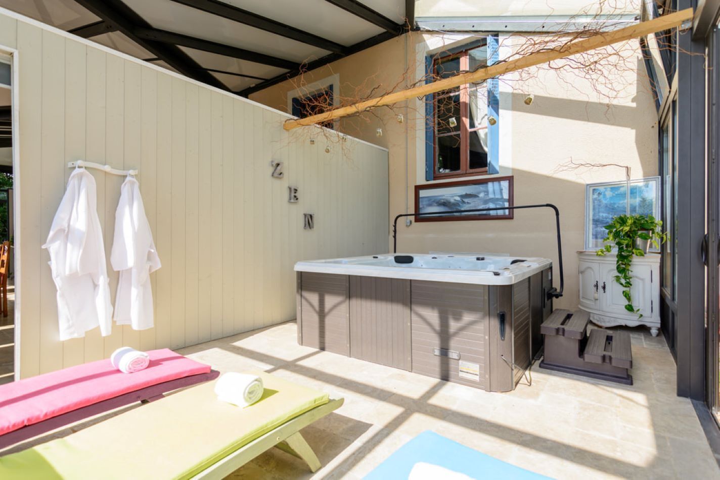 A spa area with a hot tub, towels, and a massage table.