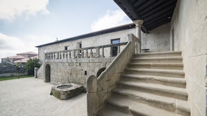 A stone building with a staircase leading to a covered area. - Reitoral de Parada (Parada de Sil)