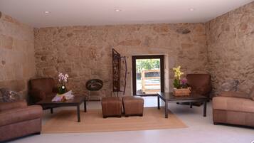 A spacious living area with stone walls, leather sofas, and a coffee table with decorative items.