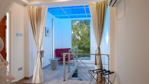 A room with a view of greenery, a red sofa, and a metal drying rack. - Design House in a famous area - St. Sebastian Curch & Temple road (Negombo/Katuwapitiye)