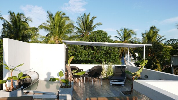 A rooftop terrace with a white pergola, seating area, and potted plants. - Design House in a famous area - St. Sebastian Curch & Temple road (Negombo/Katuwapitiye)
