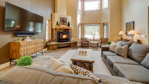 Una sala de estar con chimenea, un sofá, una mesa de centro y un televisor.